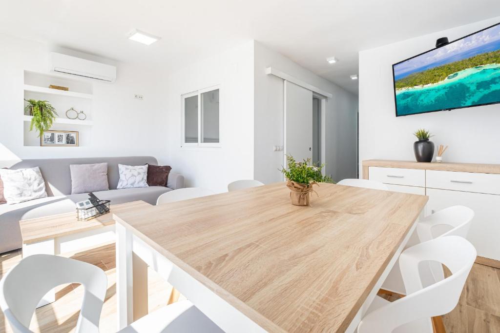 a kitchen and living room with a wooden table and white chairs at Donna II 8-38 Apartment Levante Beach in Benidorm