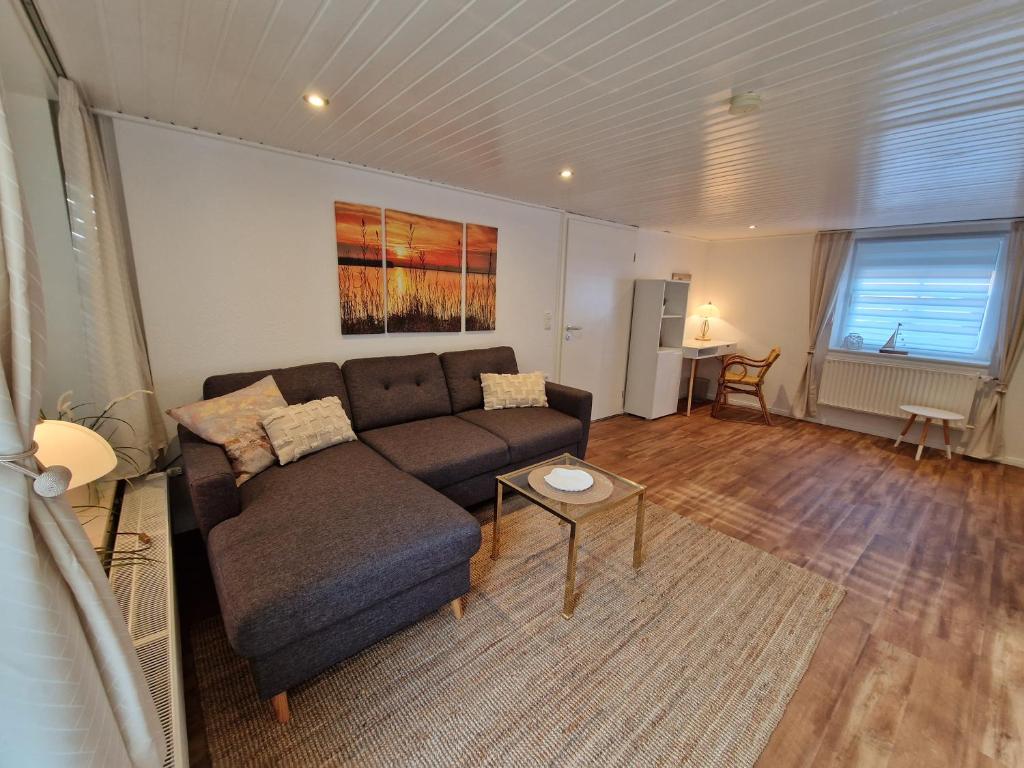 a living room with a couch and a table at Ferienwohnungen Dümmersee - Haus Alter Pferdestall in Hüde