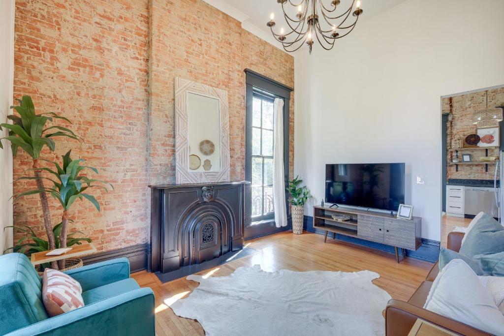 sala de estar con pared de ladrillo y chimenea en Historic New Albany Apartment about 6 Mi to Louisville, en New Albany