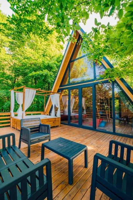 a deck with benches and tables and a tent at bungalov in Sapanca