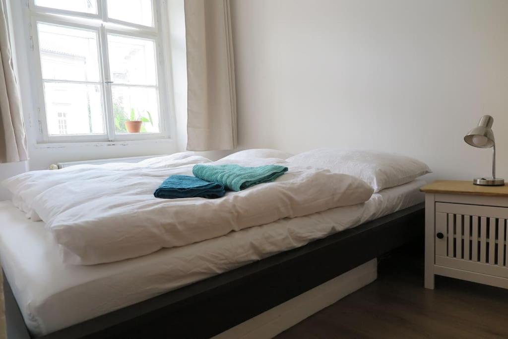 a bed with two towels on it in a room at Hradčany apartment with green energy in Prague