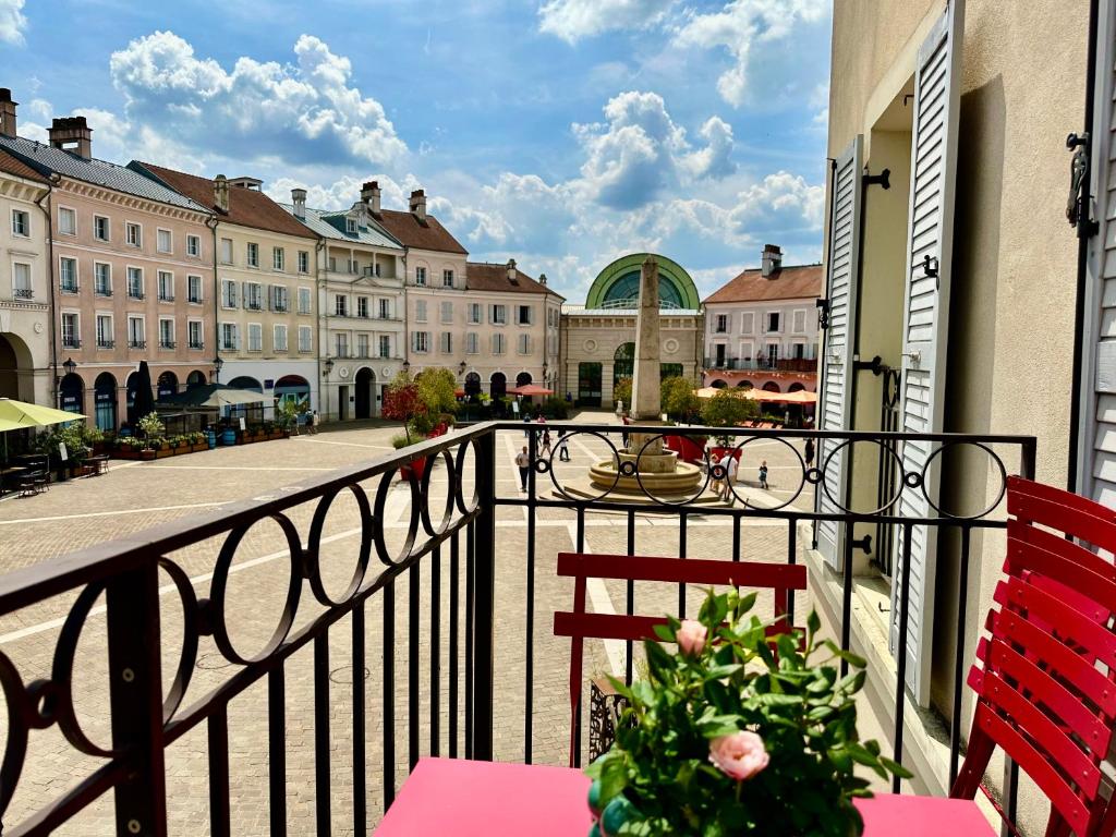 a balcony with two chairs and a table with a plant at Appt Vue Place de Toscane - 4min Disneyland-PARIS in Serris