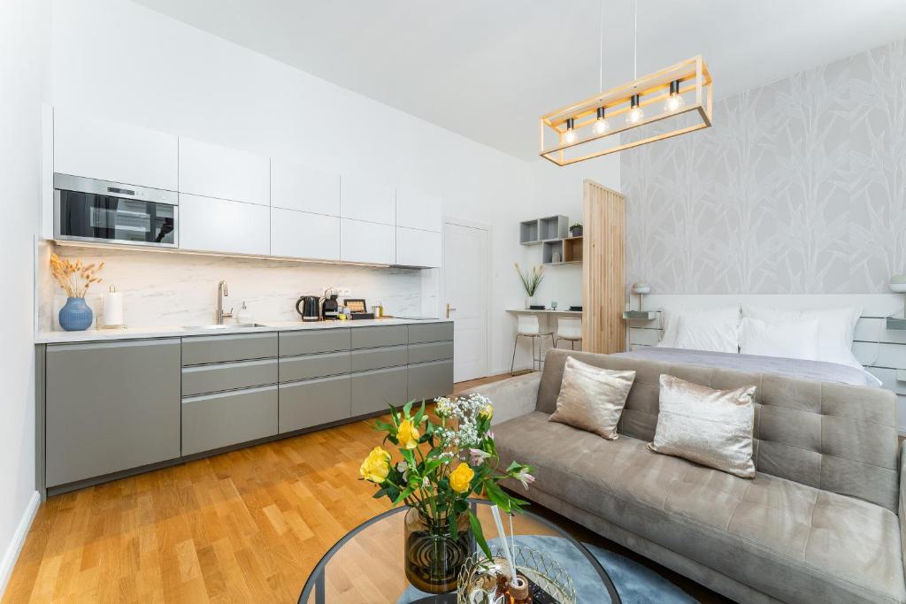 a living room with a couch and a kitchen at Anytime Holiday- Muzeum Apartments in Prague