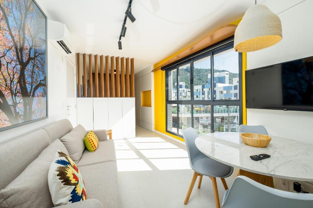 een woonkamer met een bank en een tafel bij Belíssimo e moderno studio para casais STU309 in Florianópolis
