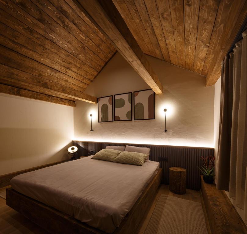 a bedroom with a large bed and wooden ceilings at Wood cabin Kolasin in Kolašin