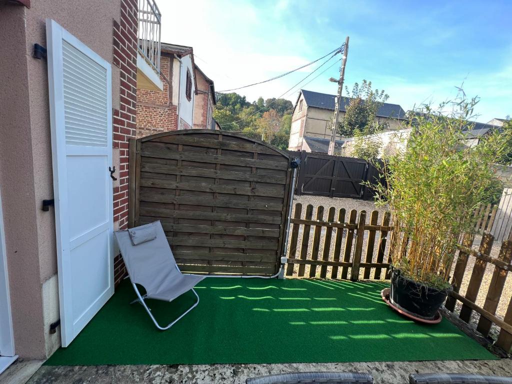 une terrasse avec une chaise et un sol vert dans l&#39;établissement Chez Jules, à Honfleur