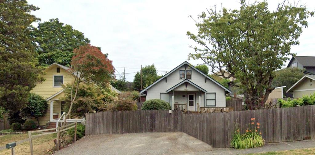 a house with a wooden fence in front of it at Northend Tacoma Charmer in Tacoma