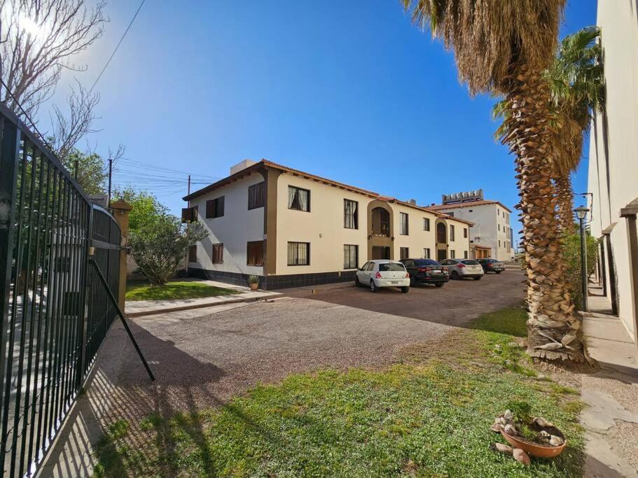 a street with a palm tree and a house at Complejo Cerrado Zona Shopping in Guaymallen