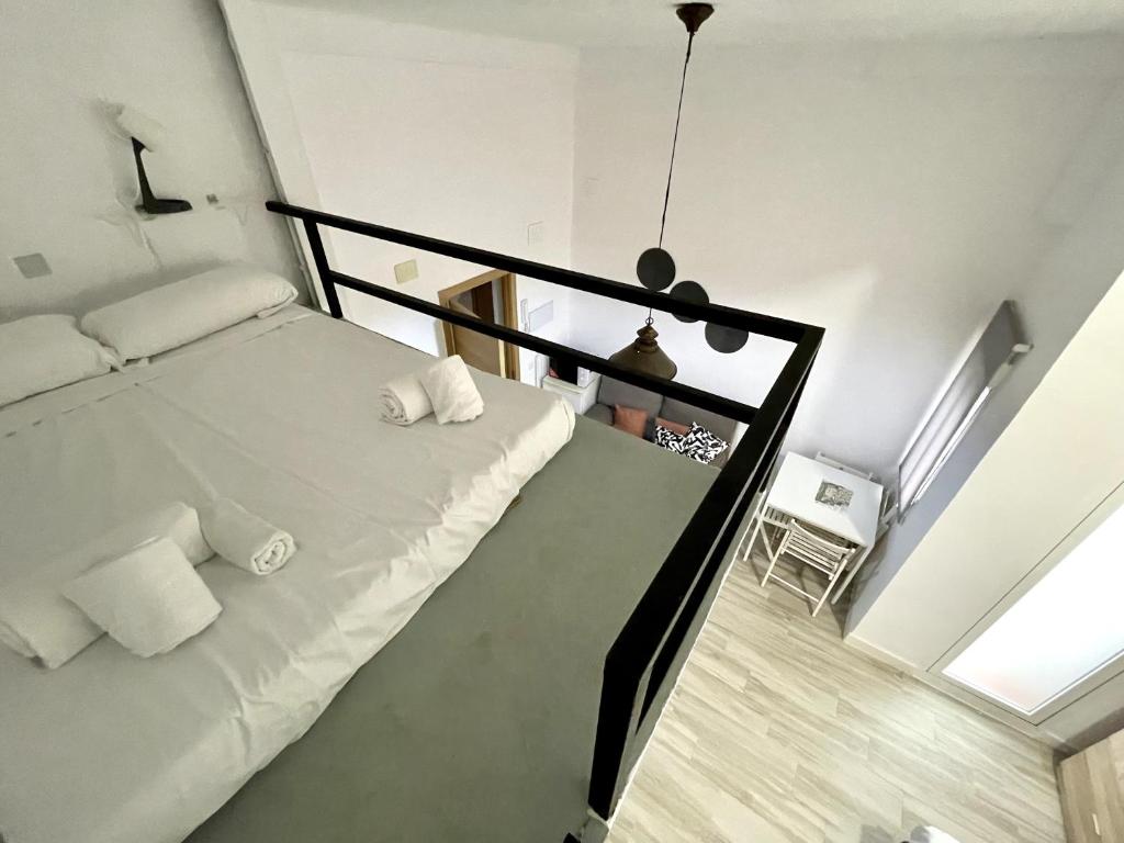 a bedroom with a white bed and a staircase at Apartamento Sotos 1 in Córdoba
