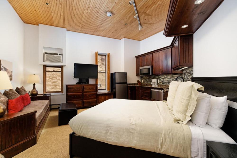 a large bedroom with a bed and a couch at Independence Square 210, Beautiful Studio with Kitchenette, Great Location in Downtown Aspen in Aspen