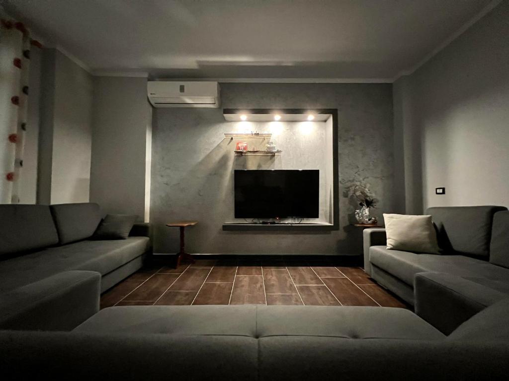 - un salon avec deux canapés et une télévision à écran plat dans l'établissement Waveside Apartment Getaway, à Durrës