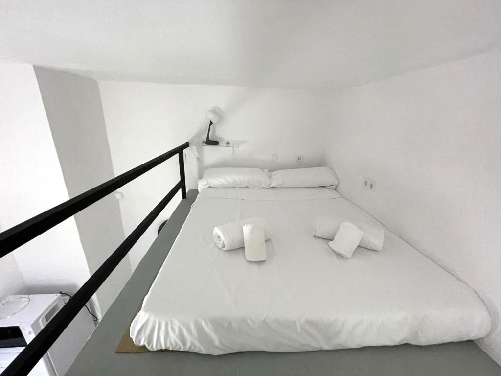 Habitación blanca con 1 cama con 2 almohadas en Apartamento Sotos de la Axerquía 2 en Córdoba