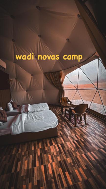 a bedroom in a tent with a bed and a chair at wadi novas camp in Wadi Rum