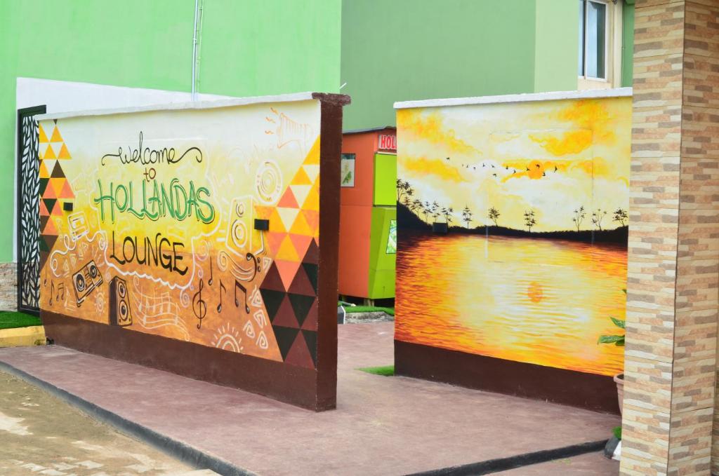 zwei Gemälde an der Seite eines Gebäudes in der Unterkunft Hollandas Hotel in Ijebu Ode