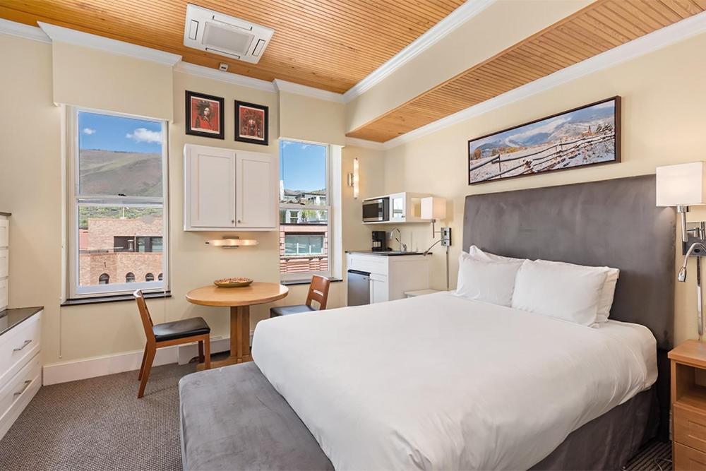 a bedroom with a bed and a table and a kitchen at Independence Square 305, Remodeled, 3rd Floor Hotel Room in Aspen's Best Location in Aspen
