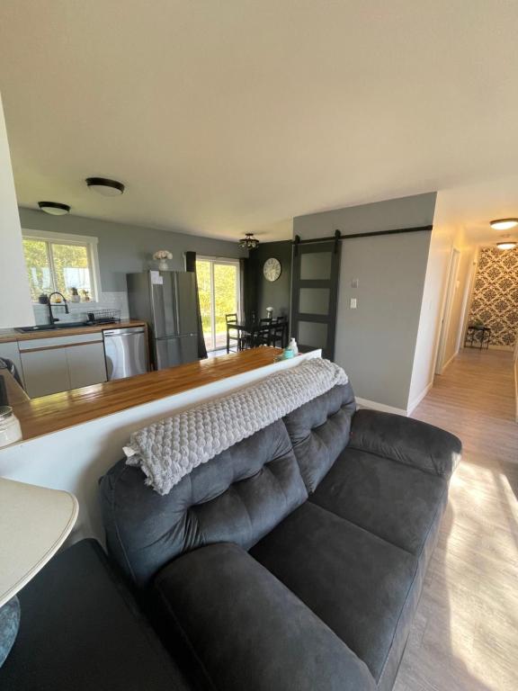 a living room with a couch and a kitchen at Sunrise Mountain view Skidegate House 