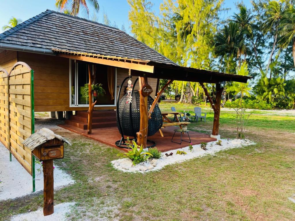 ein Haus mit einer Veranda mit einer Frau drauf in der Unterkunft Bungalow TEIPO in Teavaro