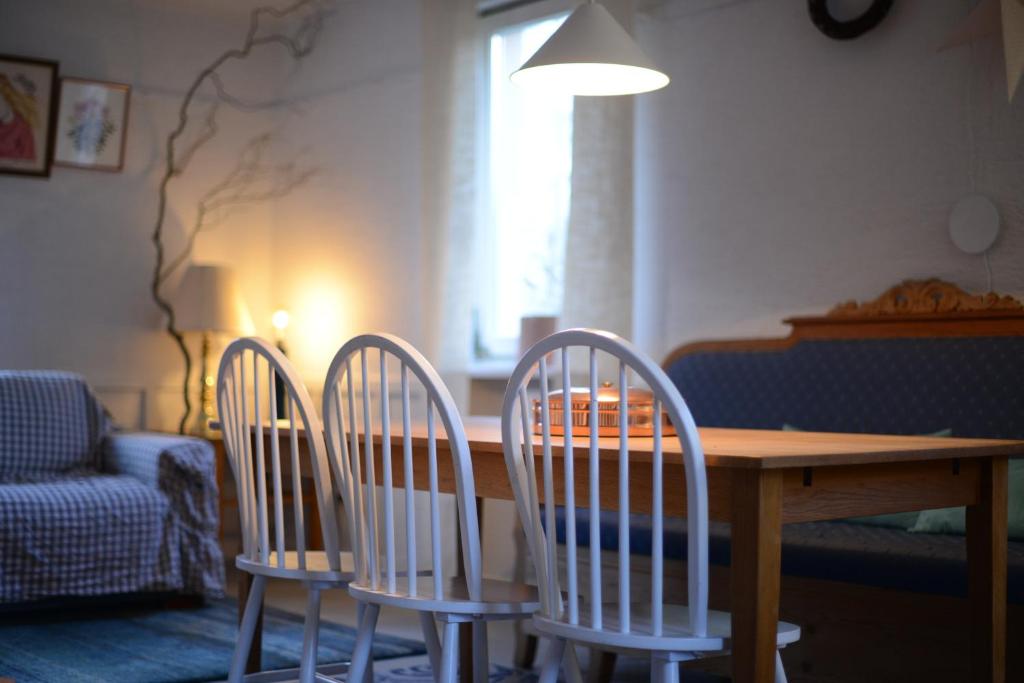 - trois chaises autour d'une table en bois dans le salon dans l'établissement Niebieski Domek, 