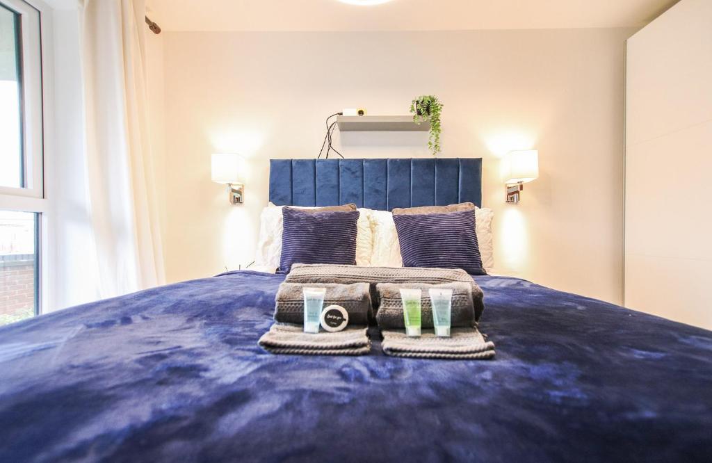 a bedroom with a blue bed with two towels on it at Luxurious 1 Bedroom West Bridgford Apartment in Nottingham