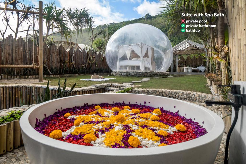 a large tub filled with flowers in a garden at Bubble Hotel Nyang Nyang - Adults only in Uluwatu