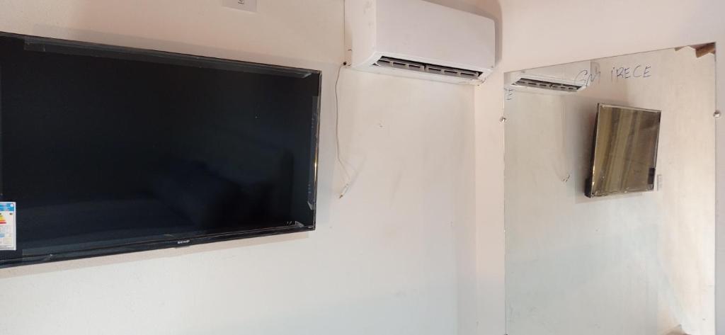 TV de pantalla plana colgada en la pared en Chalés D'Lis, en Lençóis