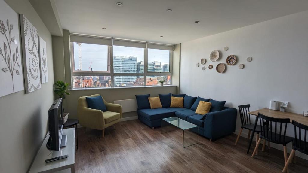 a living room with a blue couch and a table at 1 bedroom city centre apartment in Birmingham