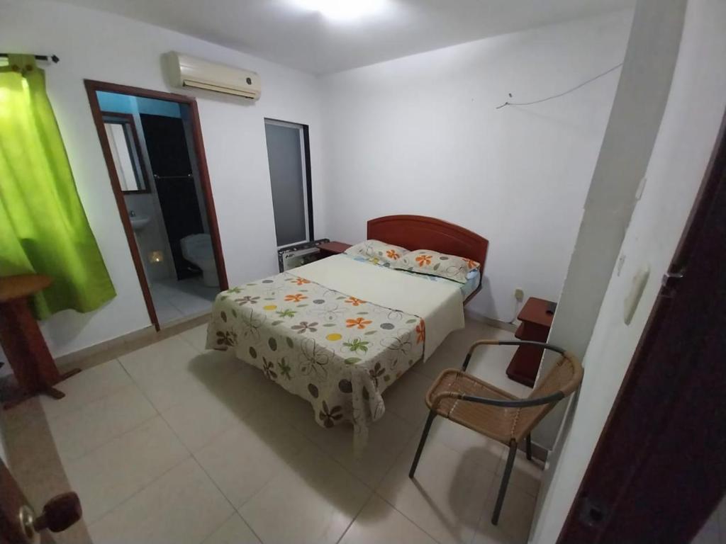 a small bedroom with a bed and a chair at Hotel Vip Comfort Santa Marta in Santa Marta