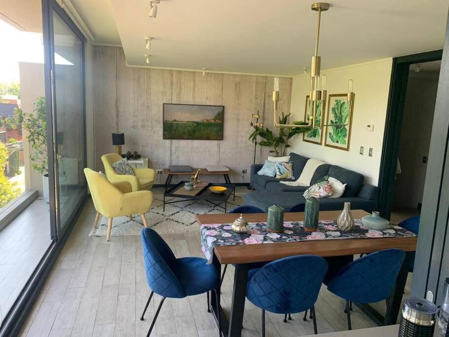 sala de estar con mesa y sillas azules en Spectacular Apartament in La Dehesa with Private Rooftop, en Santiago