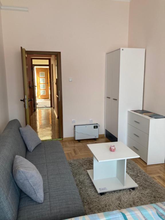a living room with a couch and a white refrigerator at Luks MM 5 in Pančevo