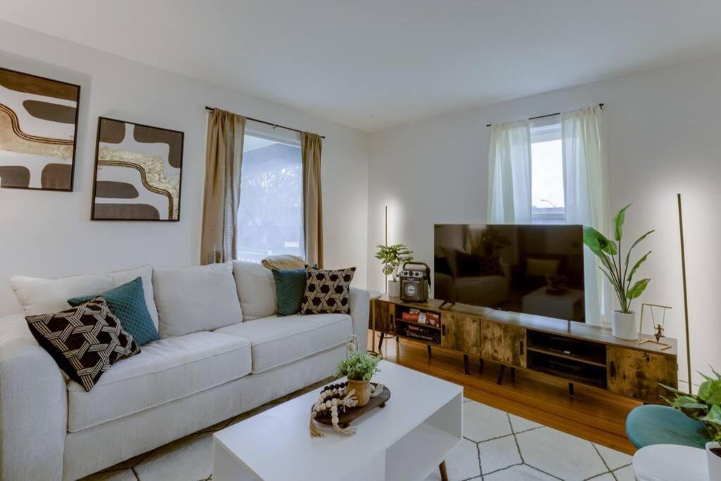 a living room with a white couch and a flat screen tv at Beautiful - 4bd with Contemporary Interior in Lincoln