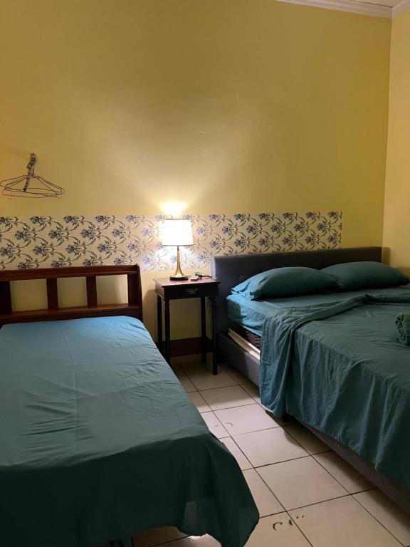 a bedroom with two beds and a lamp on a table at Emerald Apartments INC in Georgetown