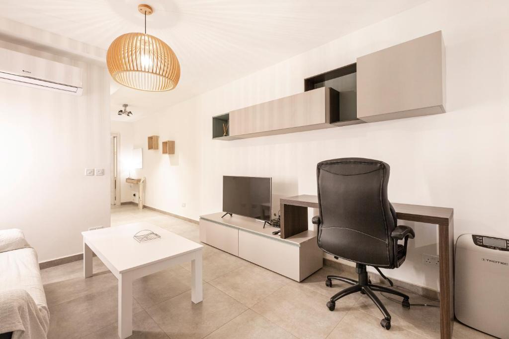 um escritório com uma secretária e uma cadeira num quarto em Top location! Cozy 1-BR flat em Il-Gżira