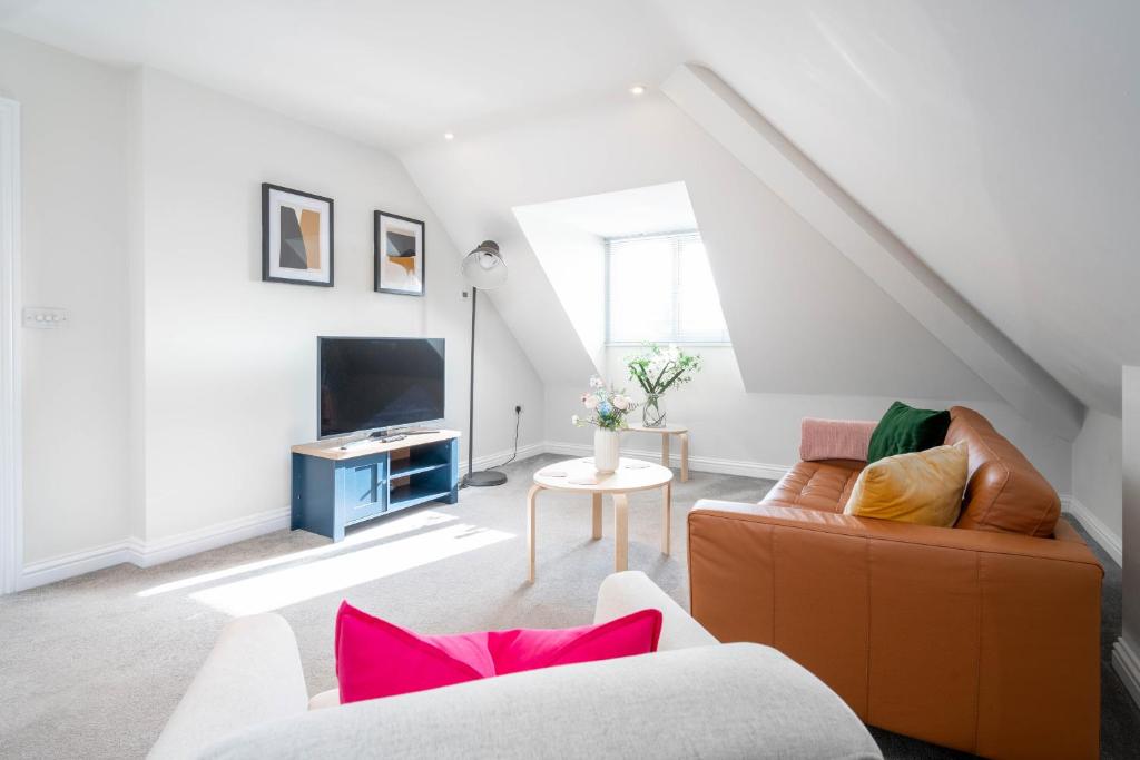 ein Wohnzimmer mit einem Sofa und einem TV in der Unterkunft Garland Penthouse - Large 2 bed 2 bath self contained flat in Redhill