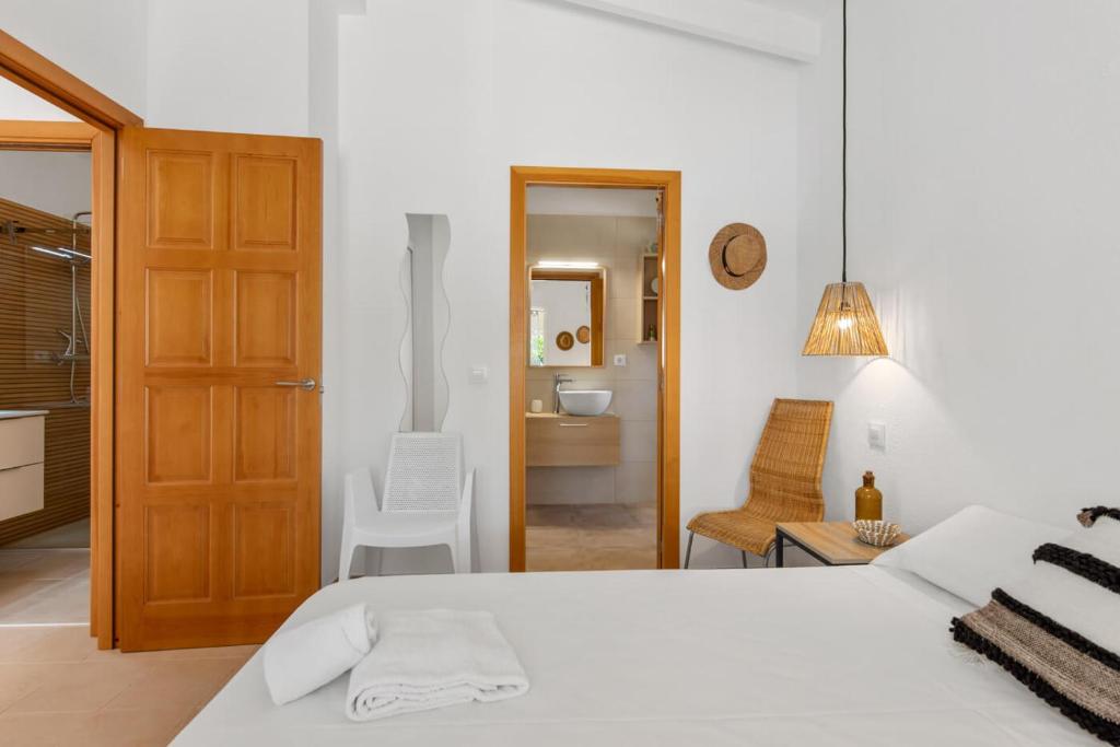 a white bedroom with a bed and a bathroom at Villa Reva - PlusHolidays in Calpe