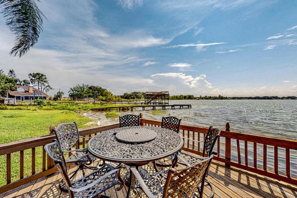 a table and chairs on a deck next to the water at Lakeside Sunset in Winter Haven