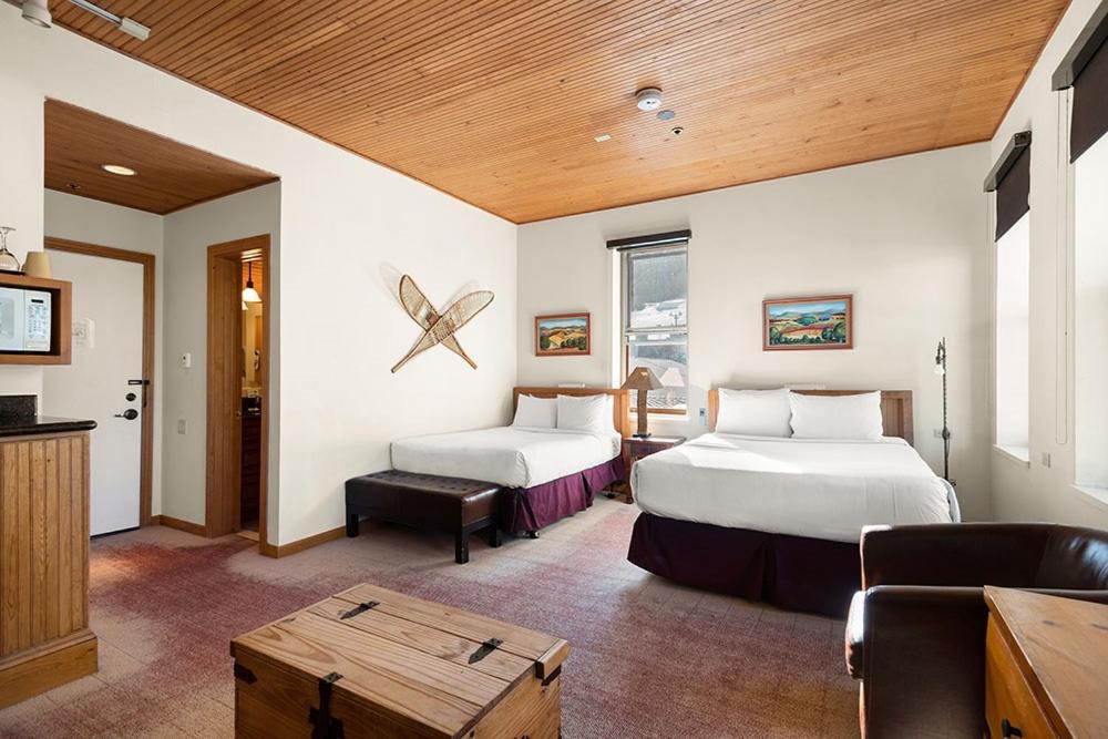 Habitación de hotel con 2 camas y mesa en Independence Square Unit 313, Downtown Hotel Room in Aspen with Rooftop Hot Tub en Aspen