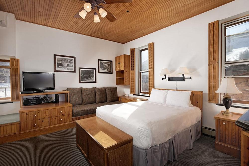 um quarto com uma cama, um sofá e uma televisão em Independence Square 311, Best Location! Hotel Room with Rooftop Hot Tub in Aspen em Aspen