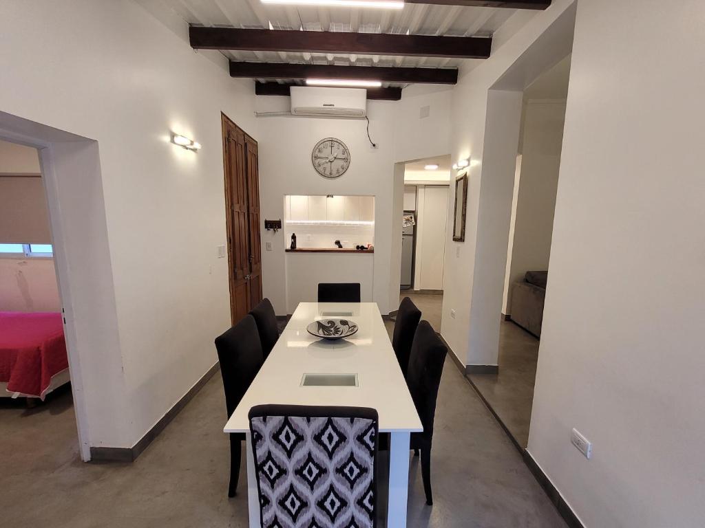 a dining room with a white table and black chairs at 9 de julio in San Miguel de Tucumán