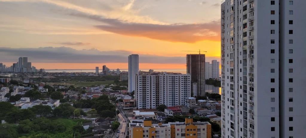 um horizonte da cidade ao pôr-do-sol com um edifício alto em Hermoso apartamento cerca a las playas de Marbella en Cartagena em Cartagena de Indias