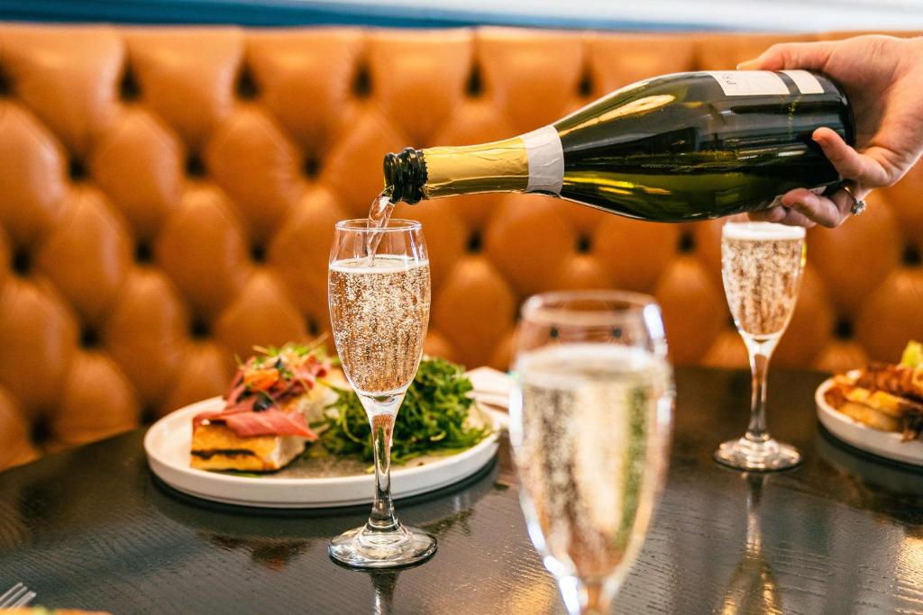 a person pouring champagne into two glasses on a table at DoubleTree By Hilton Brighton Metropole in Brighton & Hove