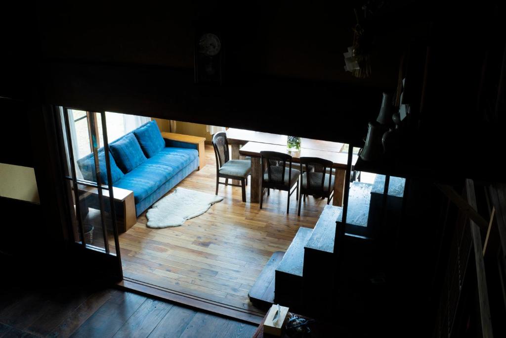 sala de estar con sofá azul y mesa en 古民家宿Tani House Itaya -セルフチェックイン en Tokamachi