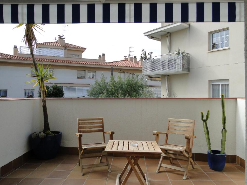un patio con 2 sillas y una mesa en el balcón en Antonio's Apartment, en Sitges