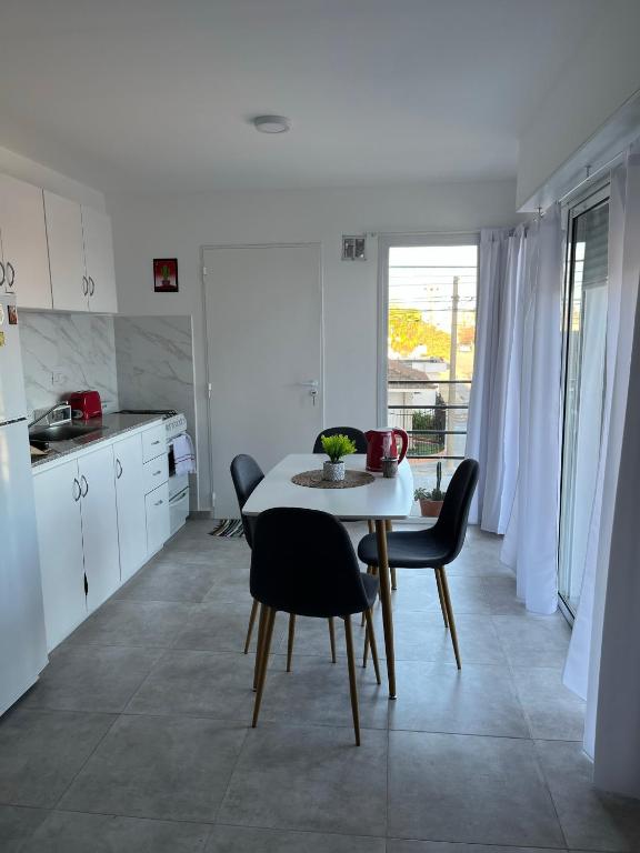 a kitchen and dining room with a table and chairs at Departamento nuevo con balcón in Olavarría