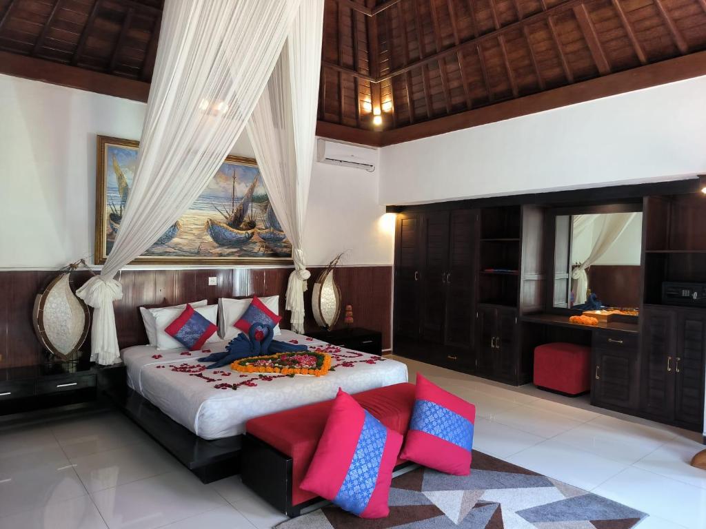 a bedroom with a large bed with red and blue pillows at Baruna Sari Villa yoga and reatret view jungle in Ubud