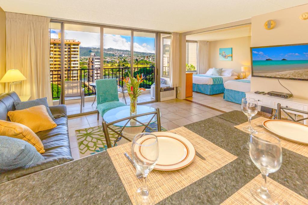 a living room with a couch and a table with wine glasses at Mountain View Condo Near Beach with Free Parking! in Honolulu