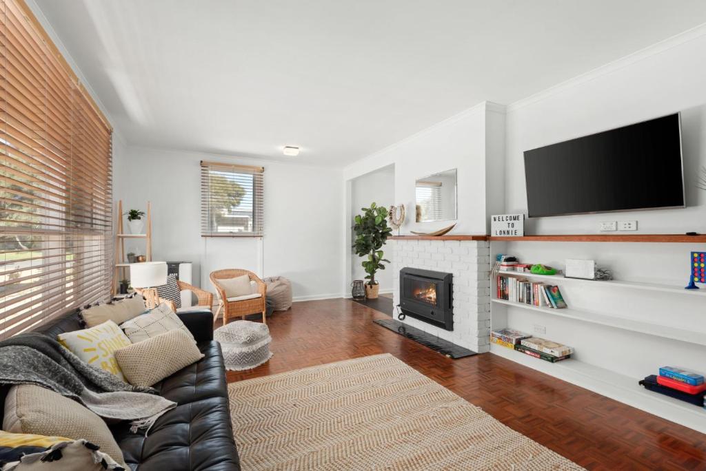 Una sala de estar con un sofá y una chimenea. en Surfside, en Point Lonsdale