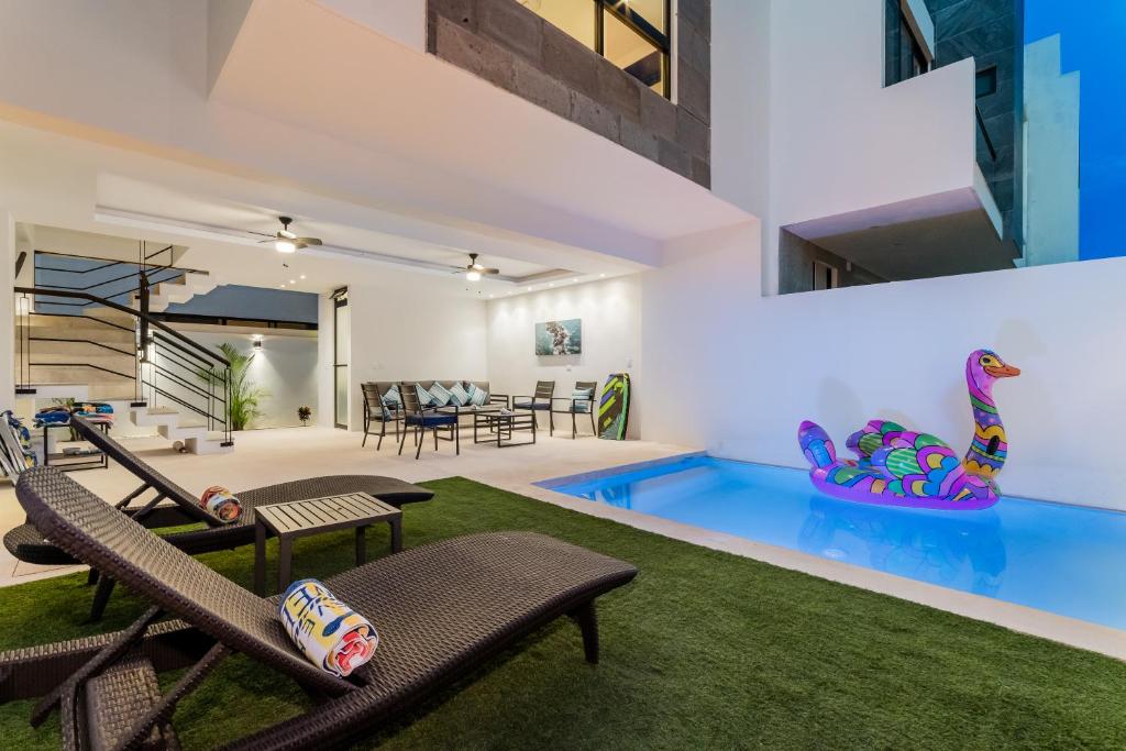 Cenote Korima - Relax in Paradise - Stunning House with Pool في كانكون: غرفة معيشة مع مسبح و منزل