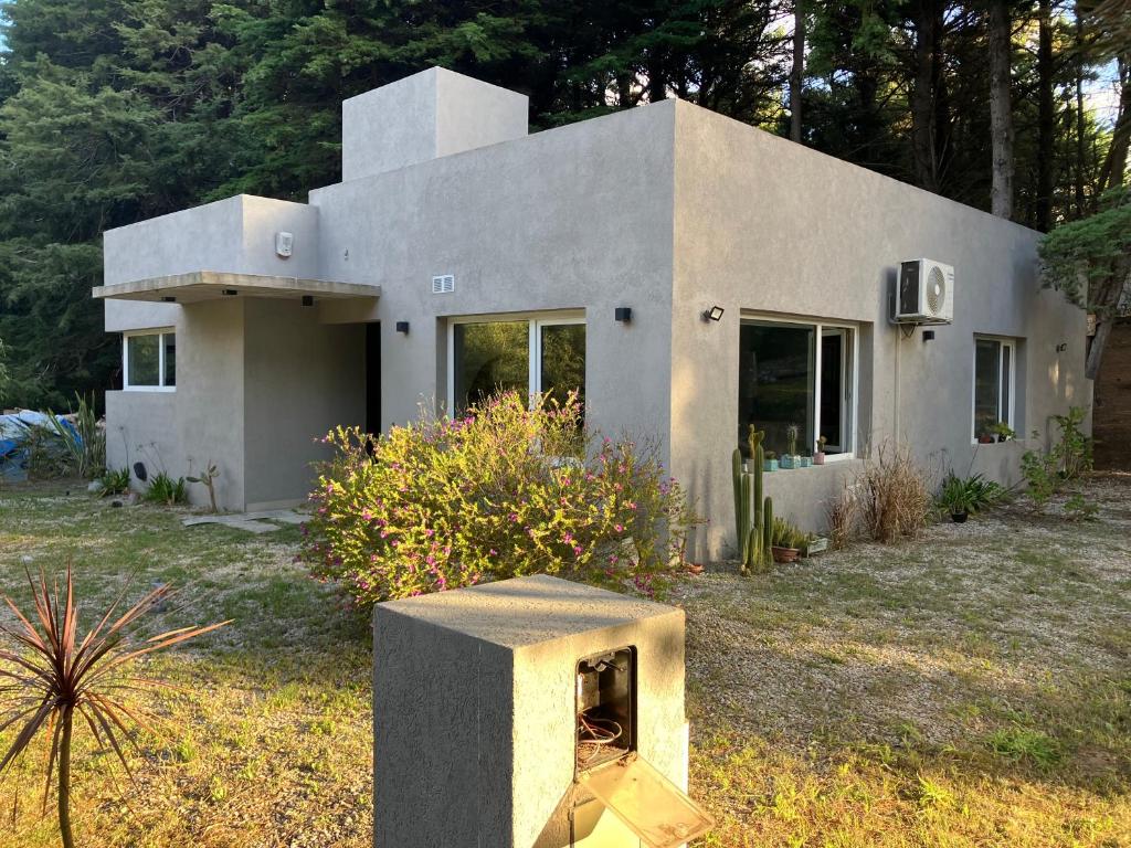 una pequeña casa con chimenea en el patio en Losgumitas 2 en Mar de las Pampas