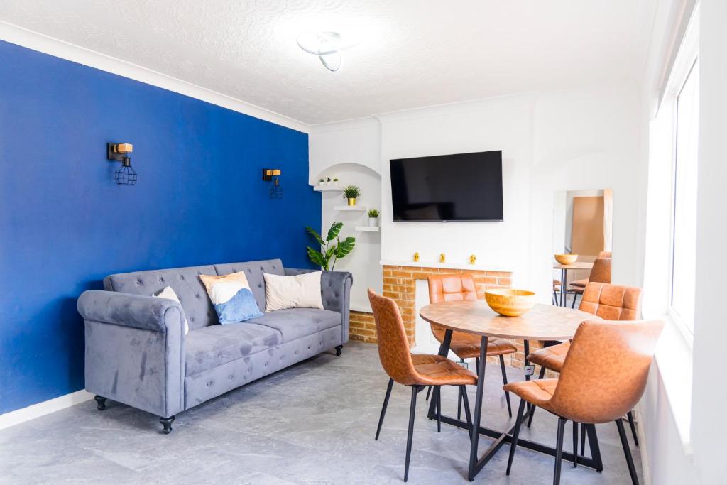 a living room with a couch and a table at 2 Bedroom House By Maison Stays - Free Parking in Nottingham