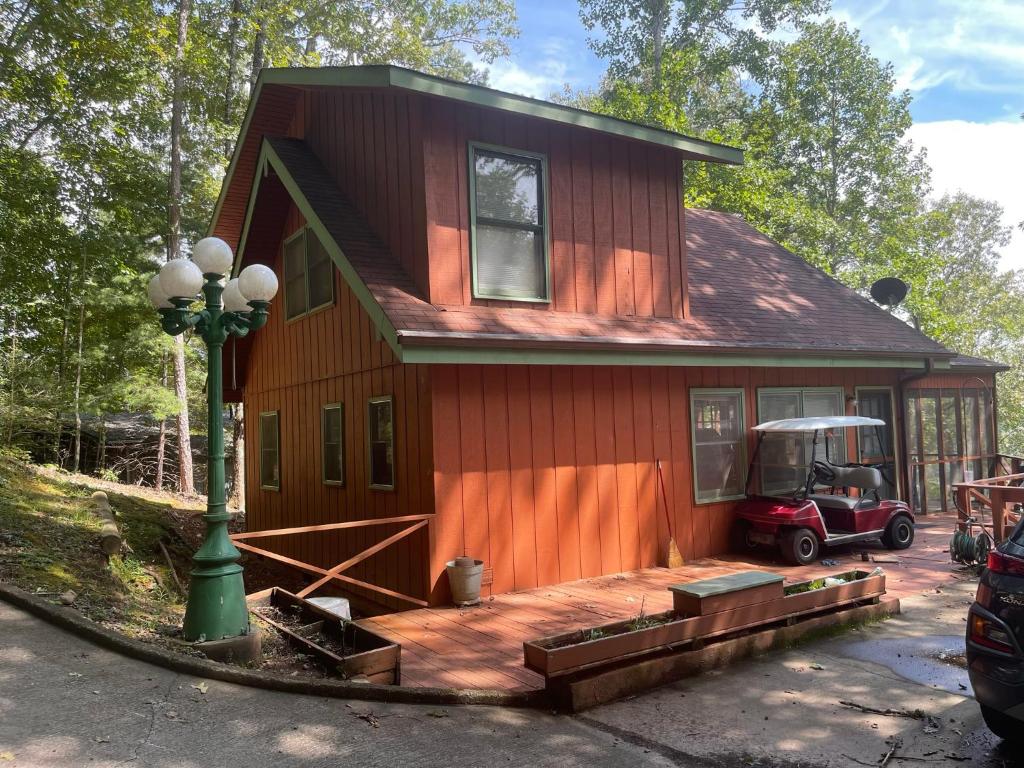 a red house with a large deck in front of it at Smokey Mountain Cabin in Murphy